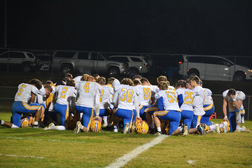 The Liberators take a knee together and bow their heads after their loss in the semifinals game, honoring their last game of the season.