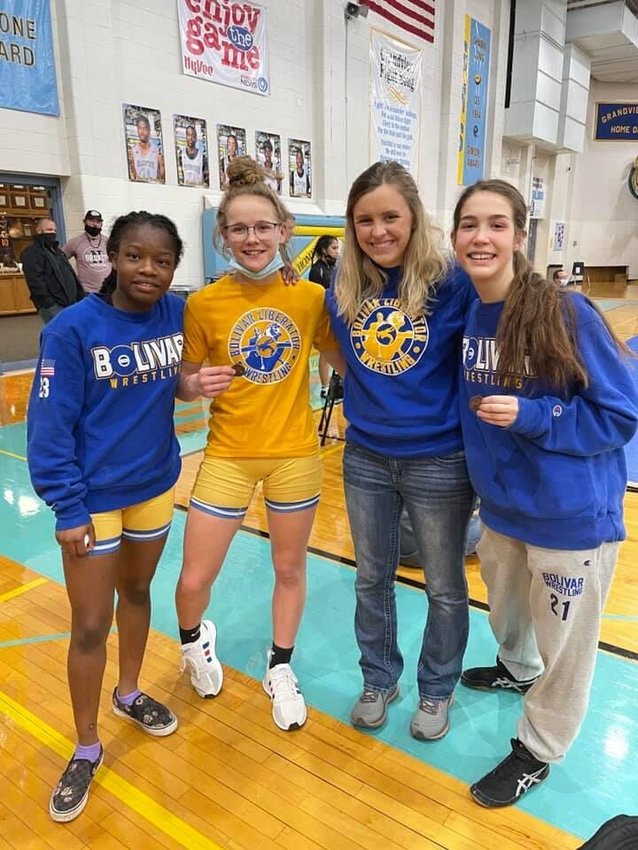 Bolivar High School girls wrestlers Charlene Barnum and Allison Butler, coach Haley Roberts and wrestler Mollie Stimpson pose for a photo at the district meet last season.