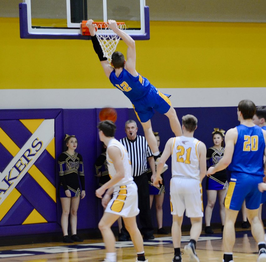 Kyle Pock swings from the rim after one of his dunks at the Camdenton game on Jan. 18.