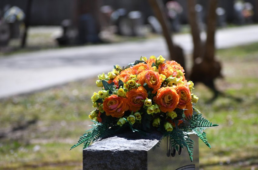 An arrangement sits atop a headstone in a Bolivar cemetery.