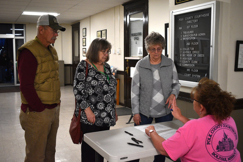 Volunteer poll workers Michael Shanks, Diana Shanks and Kathy Shockley talk with Lisa Pyle, seated, as they bring in ballots to be counted at the Polk County Courthouse Tuesday night, April 5.