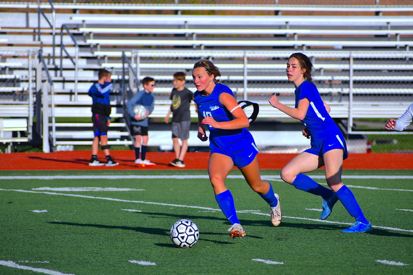 London Wilson pushes the ball up field while Mollie Stimpson offers support.
