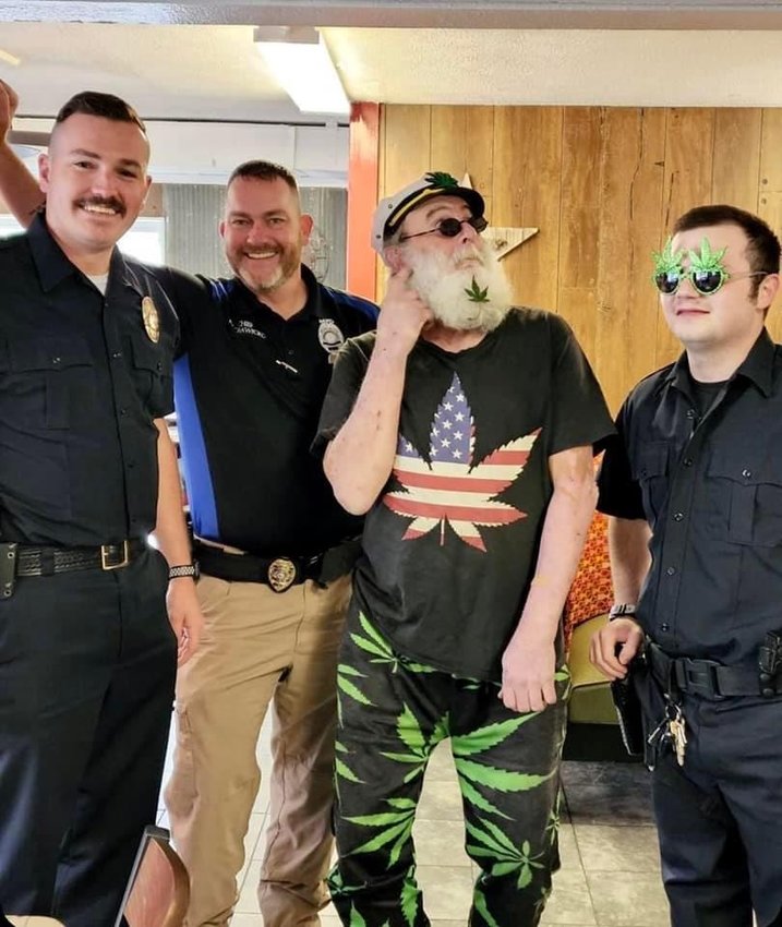 Pleasant Hope Sgt. Derek Lankford, Morrisville police chief Joe Crawford, Polk County resident John Paul Tedlock and Pleasant Hope officer Dakota French, wearing marijuana sunglasses, pose for a photo in a Pleasant Hope diner on Wednesday, April 20.