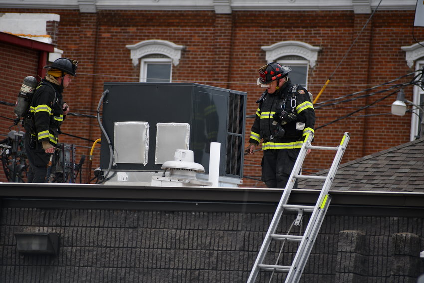 Two Bolivar City Fire Department firefighters examine an exhaust fan on the roof of the Polk County Jail on Friday afternoon, April 15.