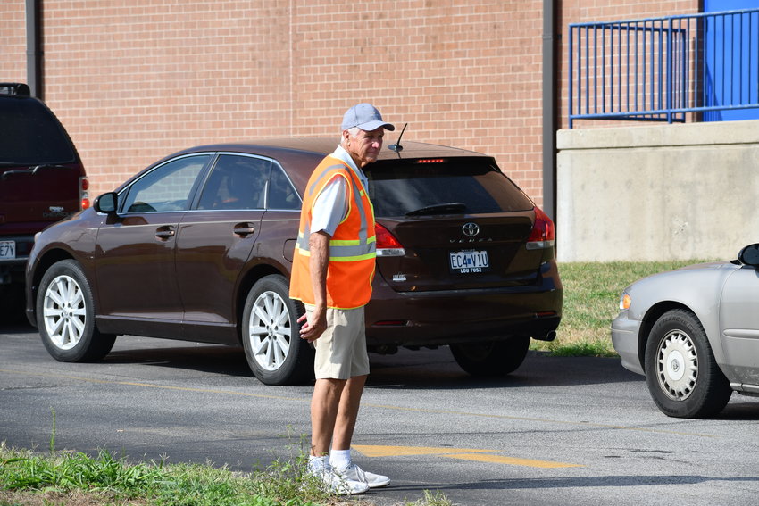 RD Vestal, one of the Methodist Dads, directs traffic at the Back To School Extravaganza on Saturday, Aug. 6. Temperatures were in the 90s by late morning, but keeping traffic flowing smoothly was a high priority as well as keeping hydrated.