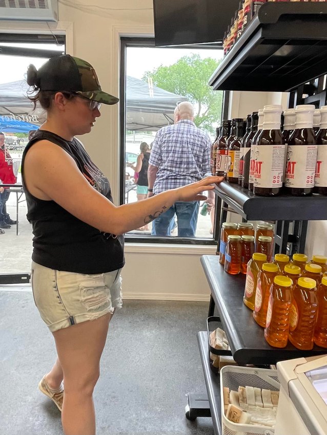 Becca Roberts, co-owner of The Butcher, checks out their inventory during The Butcher&rsquo;s ribbon cutting event on Thursday, June 9.