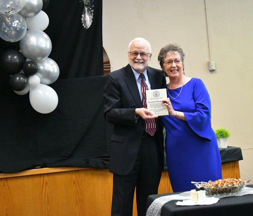 Former Judge Gary Lynch presents Judge Elizabeth Rohrs with a special plaque from the Supreme Court at the retirement reception on Wednesday, Dec. 28.   STAFF PHOTO/LINDA SIMMONS