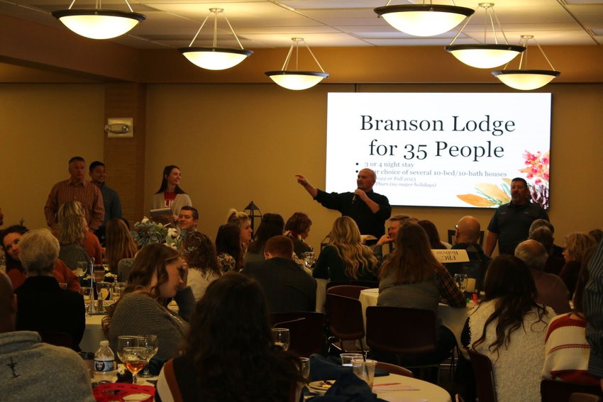 Banquet attendees are led in the bidding for a trip to Branson.    CONTRIBUTED PHOTOs