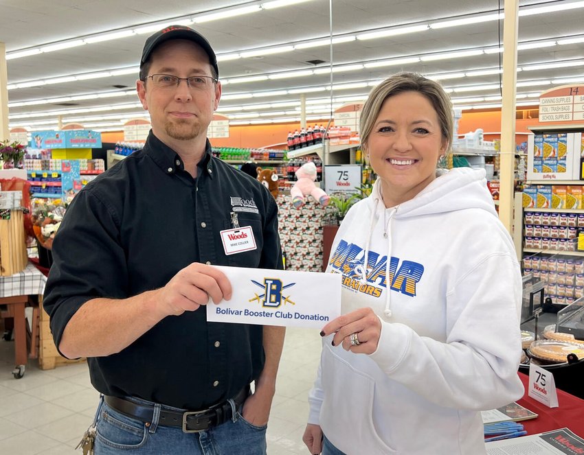 Woods unit manager Mike Collier (left) delivers a $1,000 donation to Jennifer Carr of Bolivar Athletic Booster Club (right).