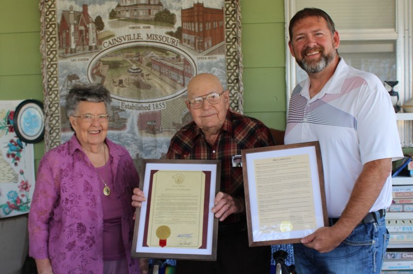 Gineth Hudson (middle) is recognized and thanked for his outstanding achievements by Bolivar mayor Chris Warwick (right) as his wife Jane Hudson (left) stands at his side.
