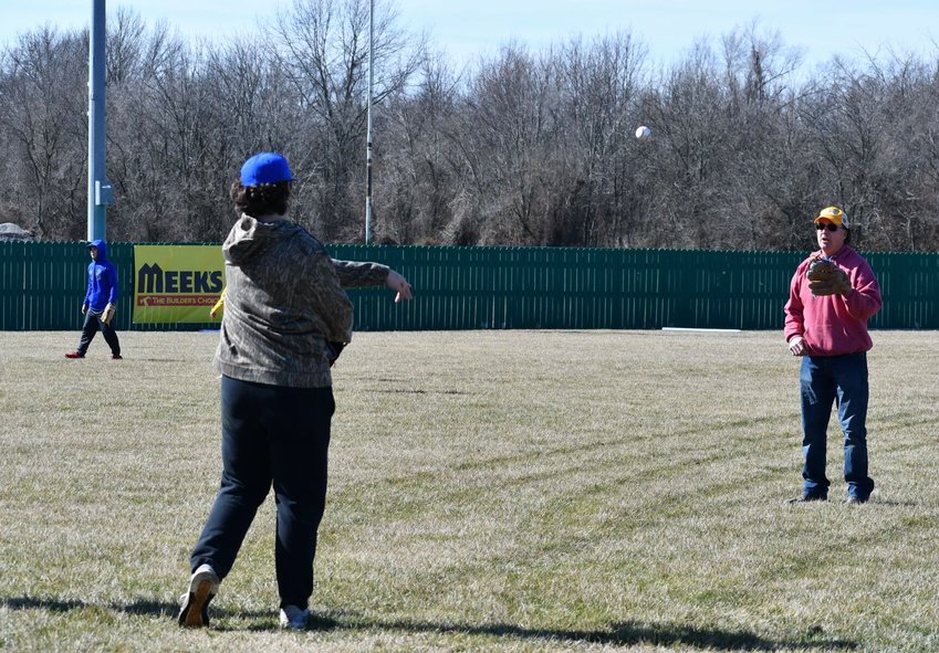 The high school Liberator baseball team joins Joe Arnold in a game of catch on Saturday, Feb. 18.