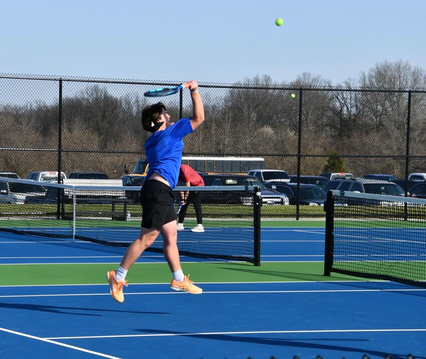 Sophomore Cooper Roberts spikes a shot in his doubles match.   STAFF PHOTO/AIDAN MAUCK