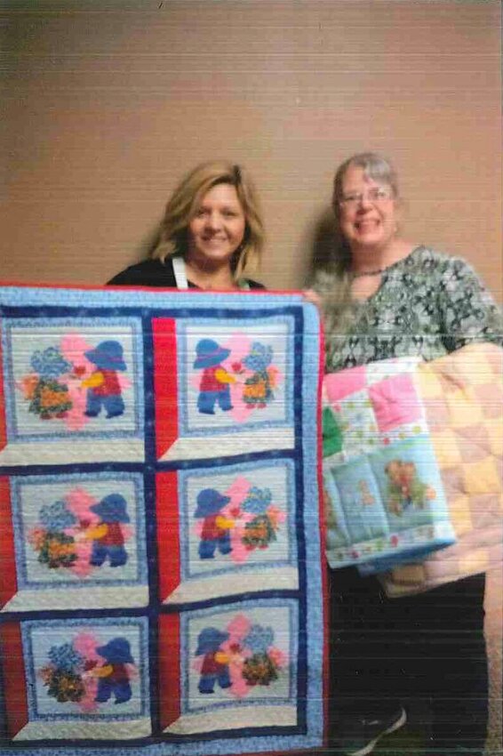 Shantelle Posten of CMH receives a donation of quilts from Becky Schnapp of the Sew &lsquo;n Sew Quilt Guild.