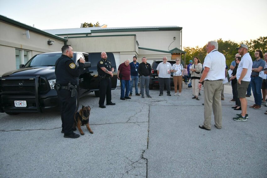 Officer Josh Nystrom and K-9 Officer Mattis, and Lt. Zach Palmer, along with Police Chief Webb give the commission a view of the police vehicles.   STAFF PHOTO/LINDA SIMMONS