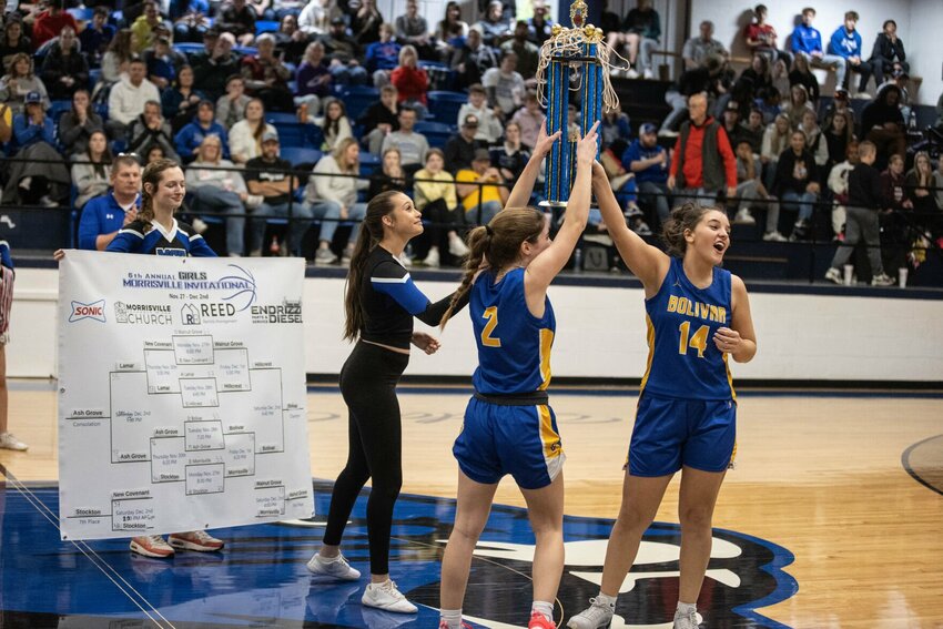 The Lady Liberator's seniors #14 Kaylynne Walker and #2 Maddy Niven raises the championship trophy.   STAFF PHOTOS/BOB CAMPBELL