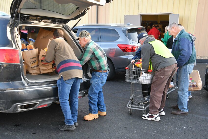 Volunteers work inside and out helping load carts full of gifts and food for the families.   STAFF PHOTOS/LINDA SIMMONS