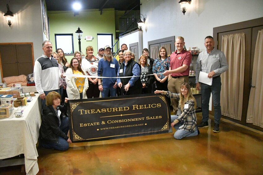 Jo Christian, owner of Treasured Relics, cuts the ribbon while surrounded by chamber members, friends and family, as well as staff members.&emsp;STAFF PHOTO/LINDA SIMMONS