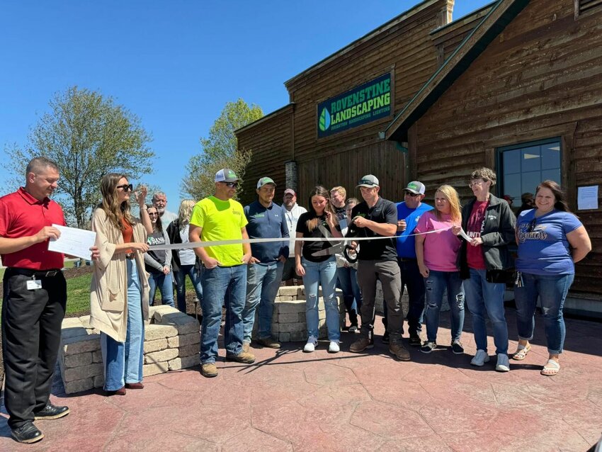 Devon Rovenstine proudly cuts the ribbon at the new Rovenstine Landscaping surrounded by chamber members, friends and family.   CONTRIBUTED PHOTO