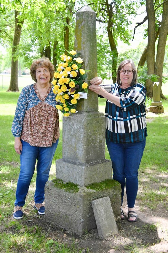 Cay Sergent and Betty Doyle, members of the Polk County Genealogical Society, placing flowers for those that can't visit in person.   STAFF PHOTO/LINDA SIMMONS