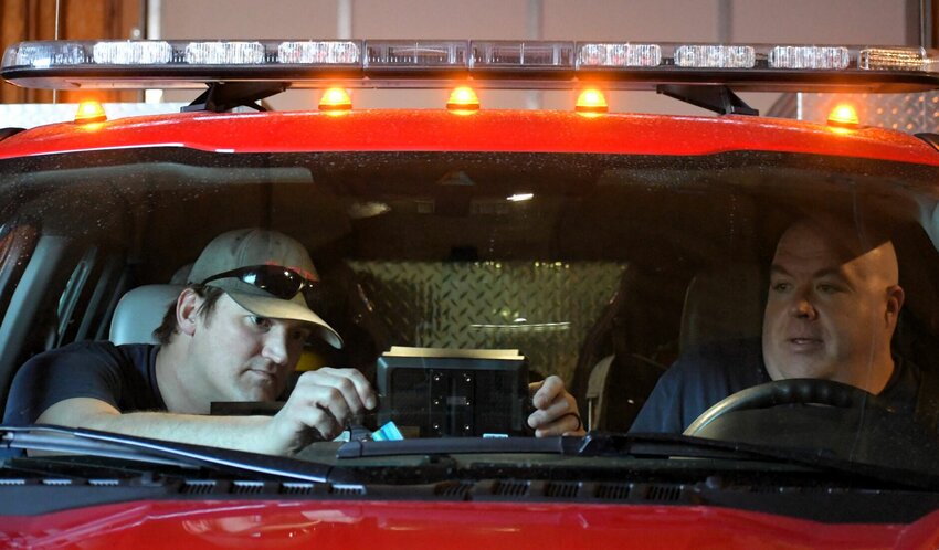Firefighter Lucas Hadley, left, and Capt. John Kendall, right, install a new HAAS Alert Safety Cloud digital system in one of the Bolivar City Fire Department's vehicles.   CONTRIBUTED PHOTO