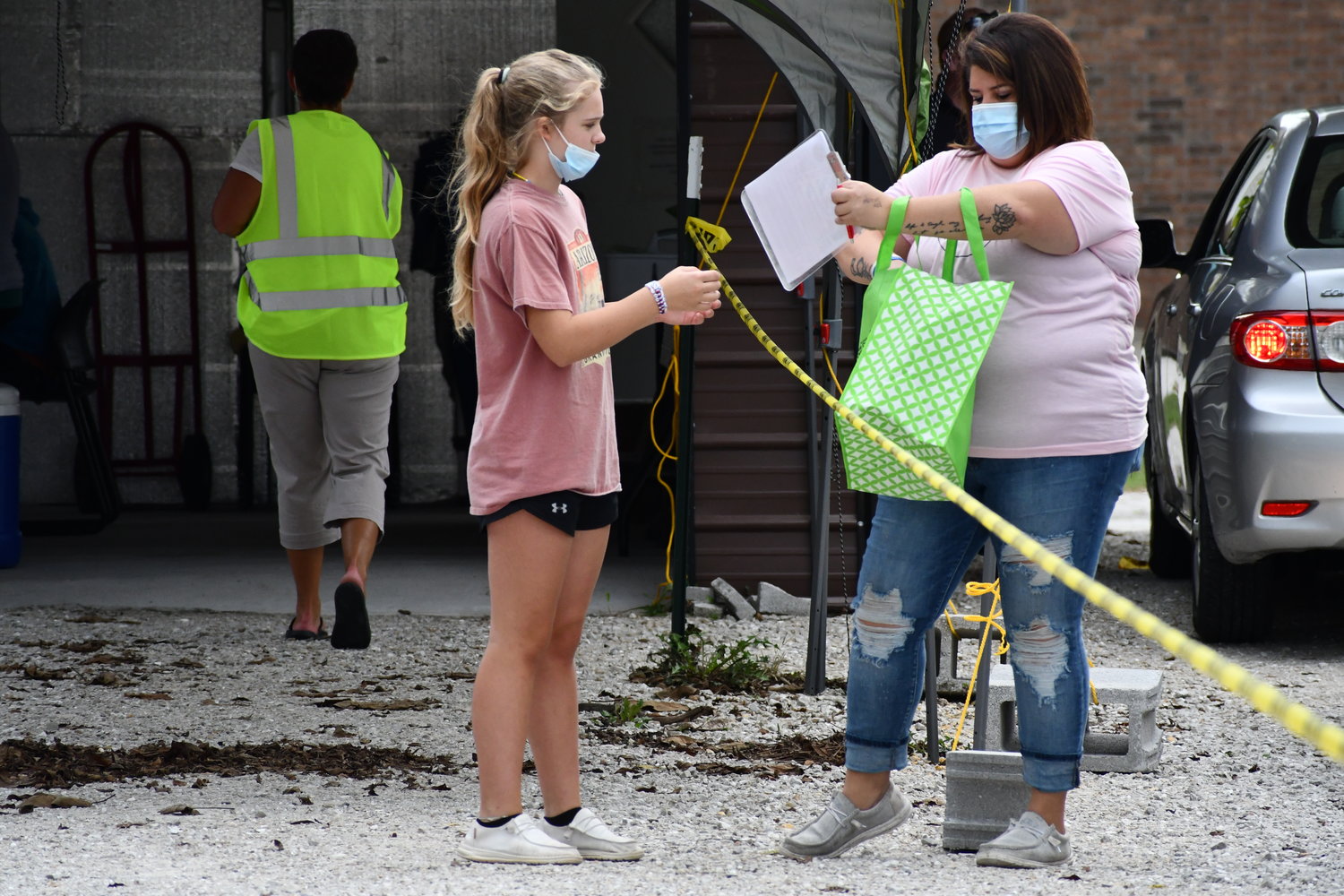 Payton Lister and Mellissa Cook get paperwork organized at the mass vaccination event.