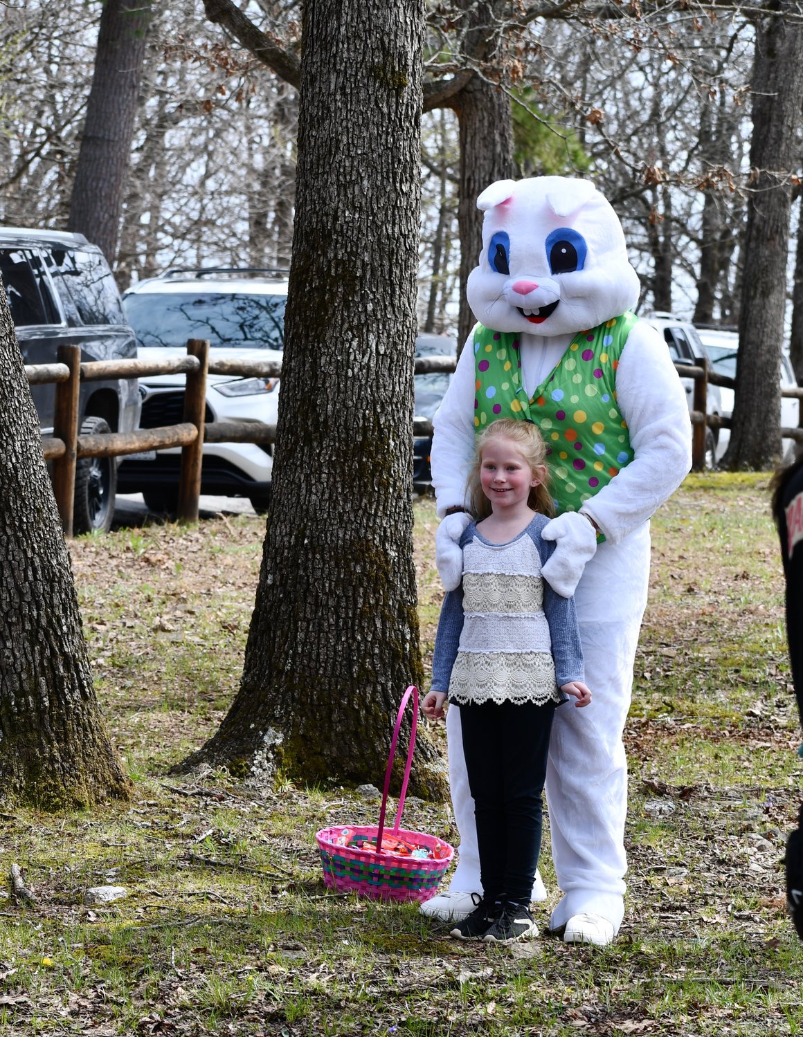Cora Reynolds smiles as she poses with the Easter Bunny at the park on Saturday, April 16.
