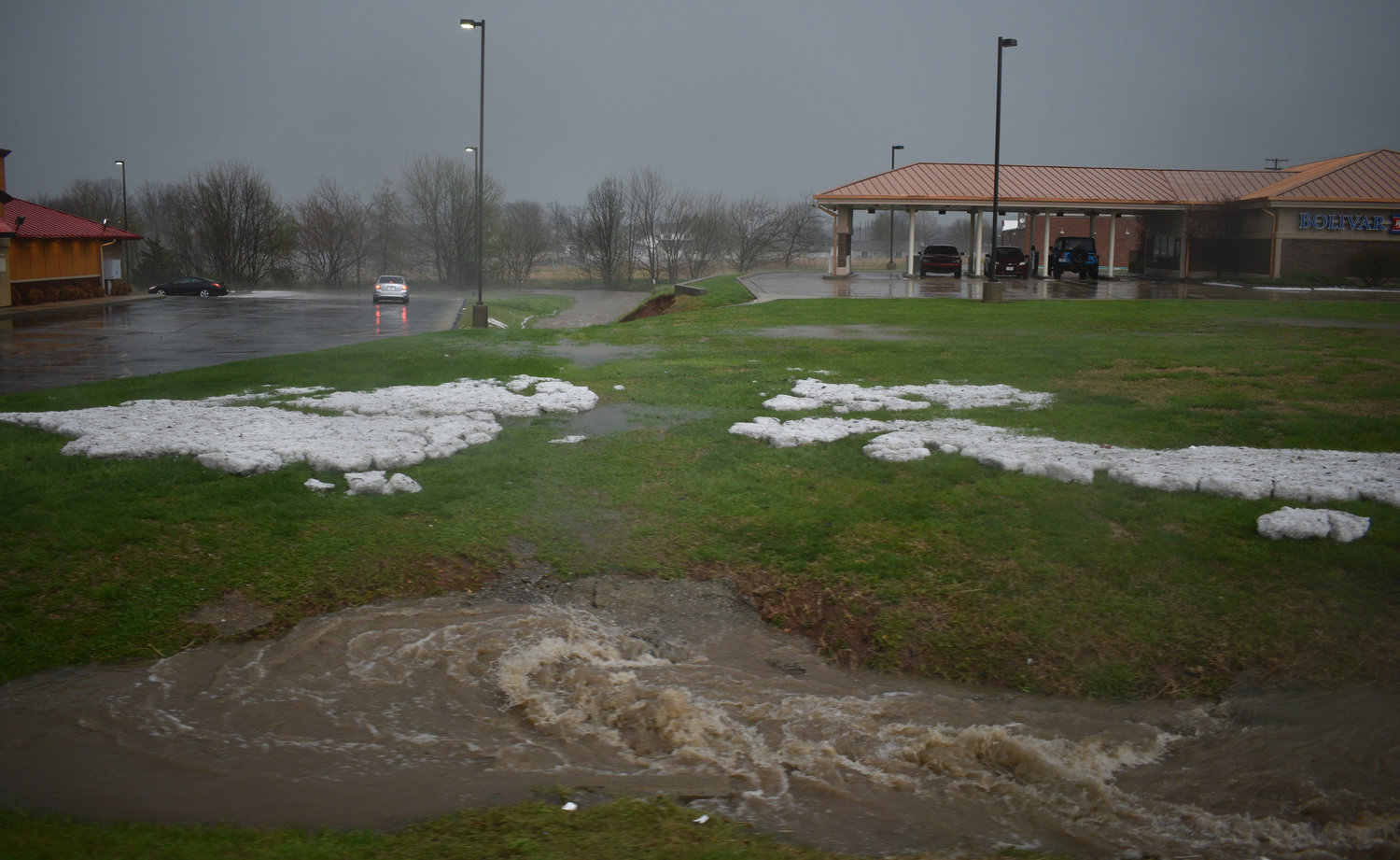 Piles of hail and swirling flood waters appear on South Springfield Avenue.