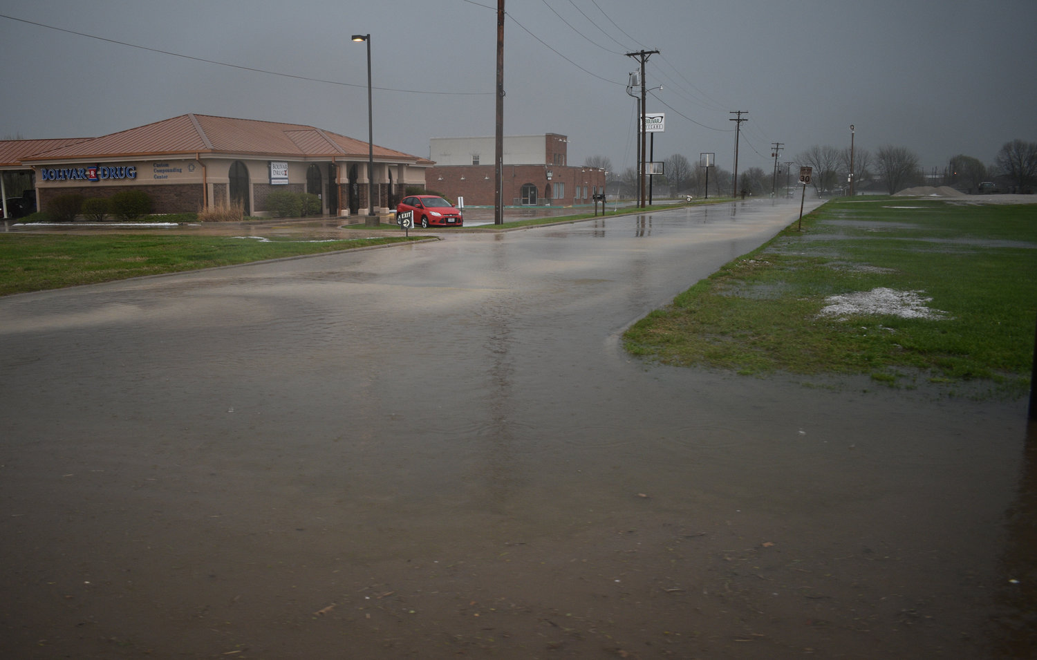 Water floods the roadway at the intersection of South Springfield Avenue and East Cambridge Street.