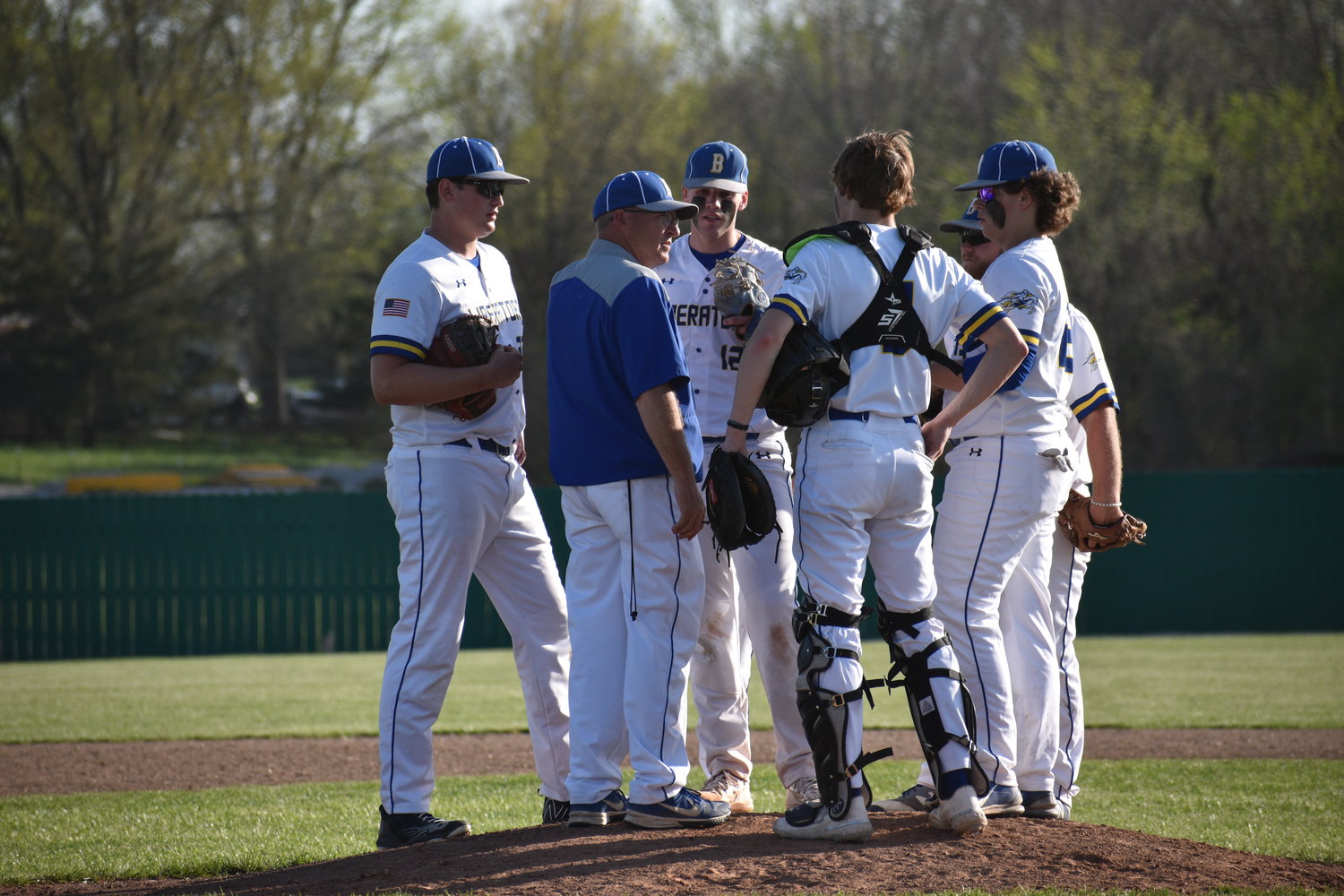Bolivar varsity head coach Brad Roweton holds a conference with his infield staff on the mound.