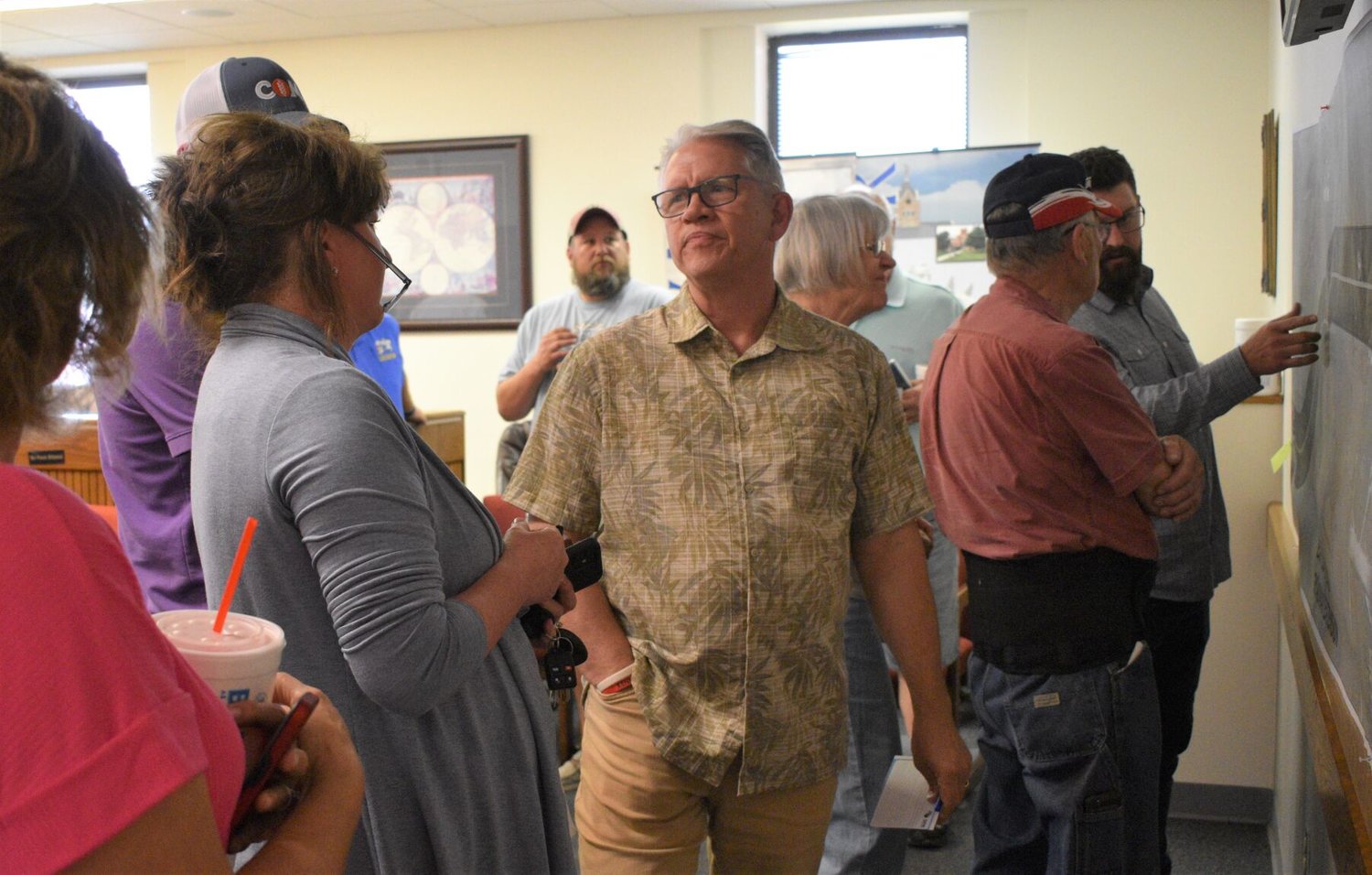 Community members look over an initial map and talk about the East Loop Road project at an open house at Bolivar City Hall in June.