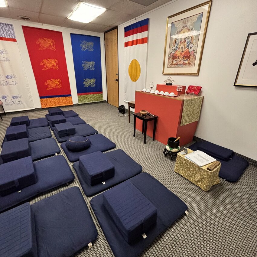 Cushions line the floor of a practice space at Shambhala Dallas Meditation Center, surrounded with traditional Tibetan banners and Buddhist imagery.