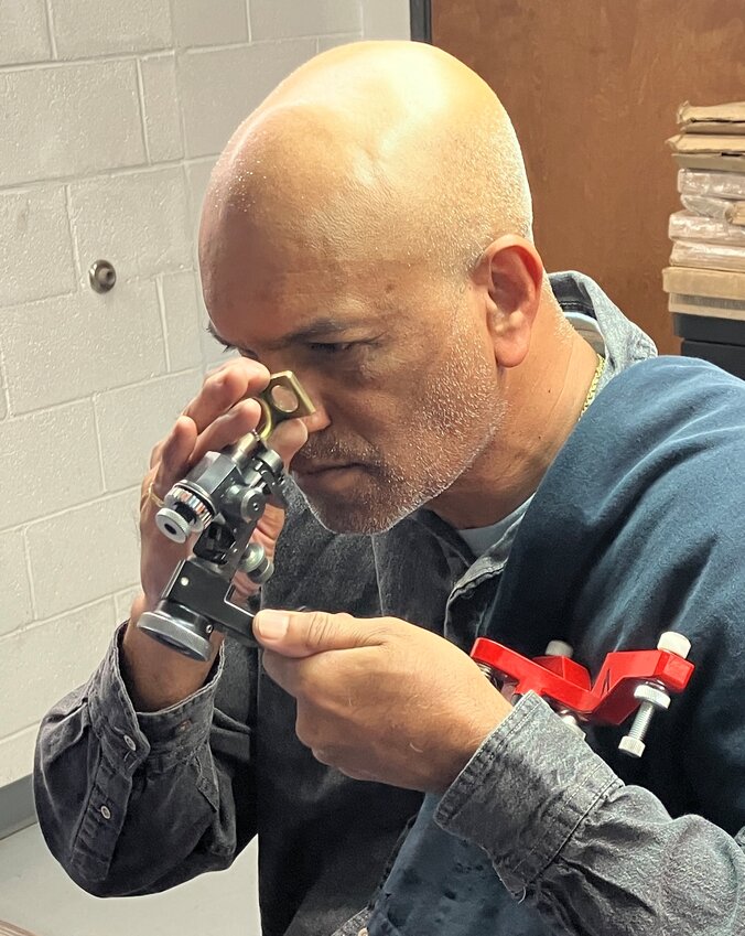 Vishnu Lutchanah meticulously examines the diamond he cuts Aug. 20 at his workstation at The Diamond Factory