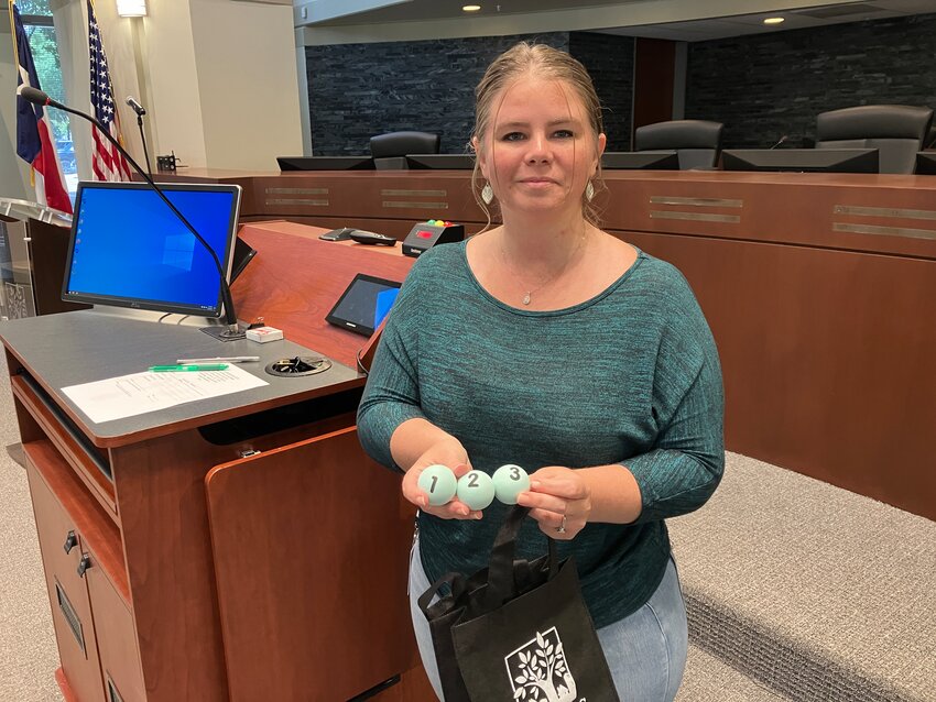 Erin Flores, deputy city secretary, shows the balls used to determine candidates' positions on the ballots.