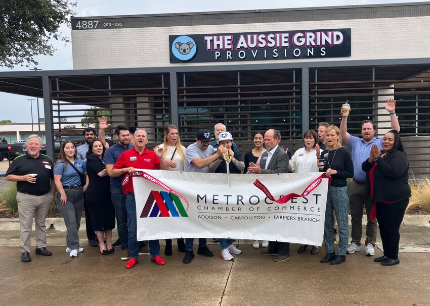 Lui and Angie Monforte (center with scissors) cut the ribbon to the hoots and hollers of members of the Metrocrest Chamber on Tuesday, Aug. 3.