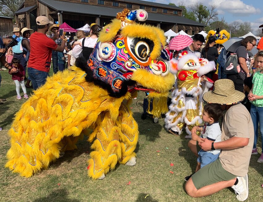 Arlo and his dad, Tommy Tran, meet a dancing lion up close Saturday, March 29, at Gateway to the Globe.