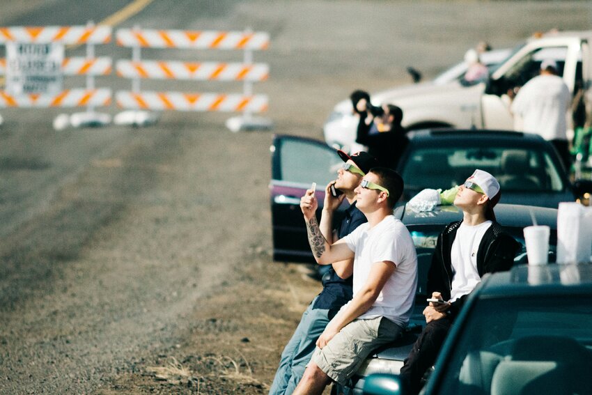 People watch a solar eclipse from a designated parking area.