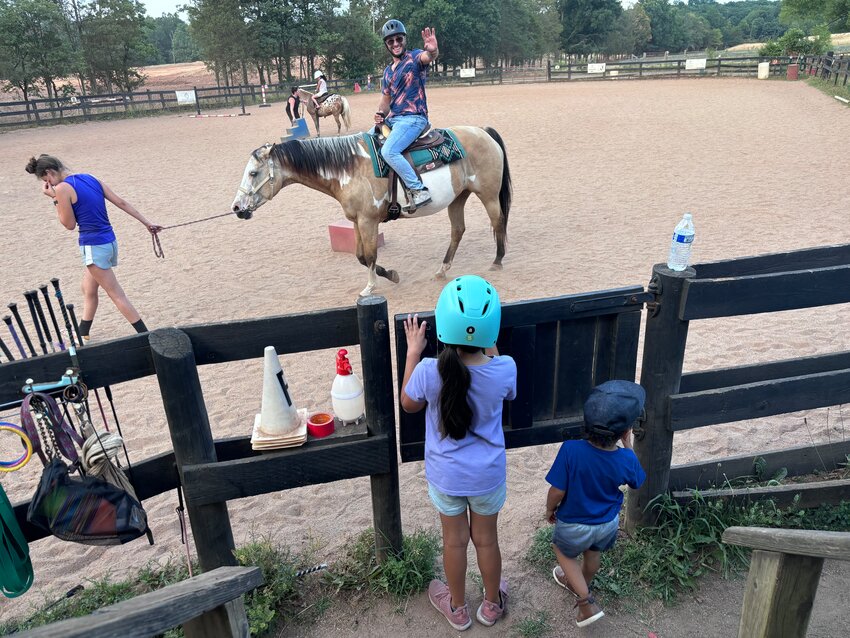 Bristoe Station residents waves at his children as he rides past on a horse at Silver Eagle Stable of Nokesville.