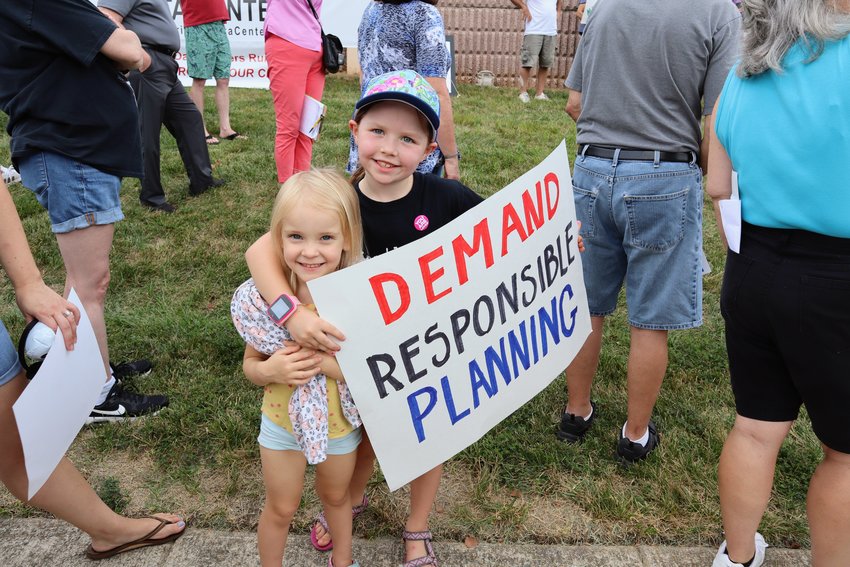 Local children hold hand-painted signs demanding planning reform. 