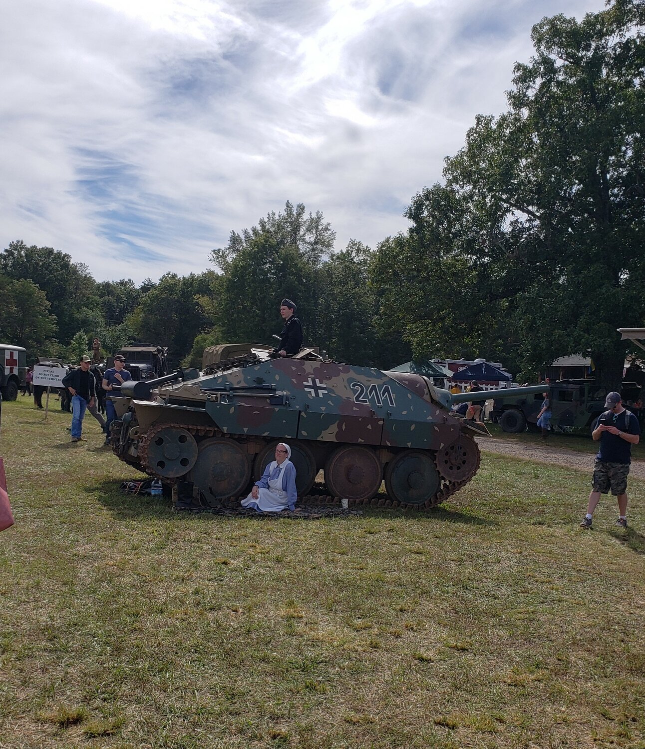 A visitor explores a historic tank at the AWE open house.