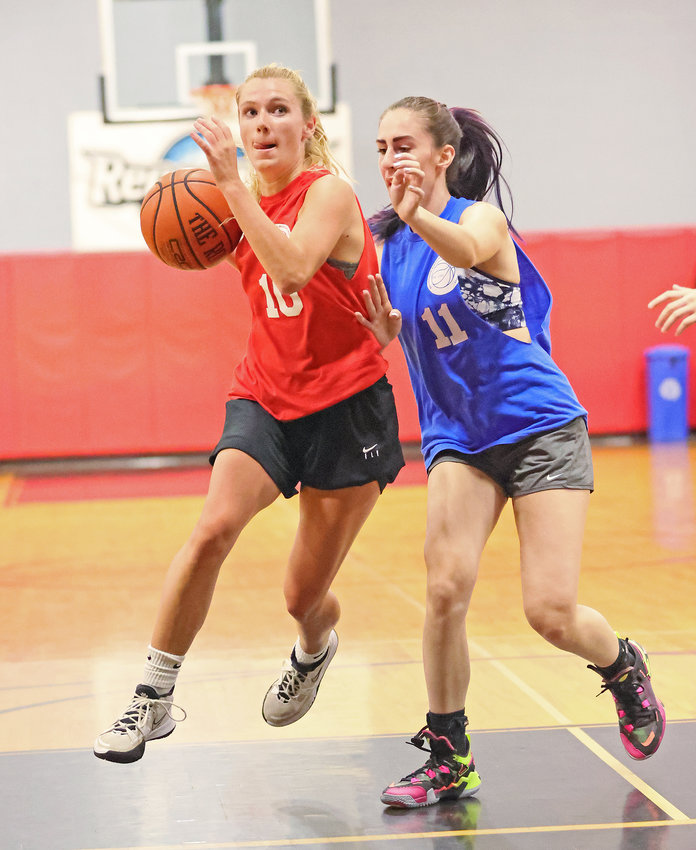 CHC Red senior Abby Spratt (left) floats down the lane past Royal Blue's Aaliyah Fisher.
