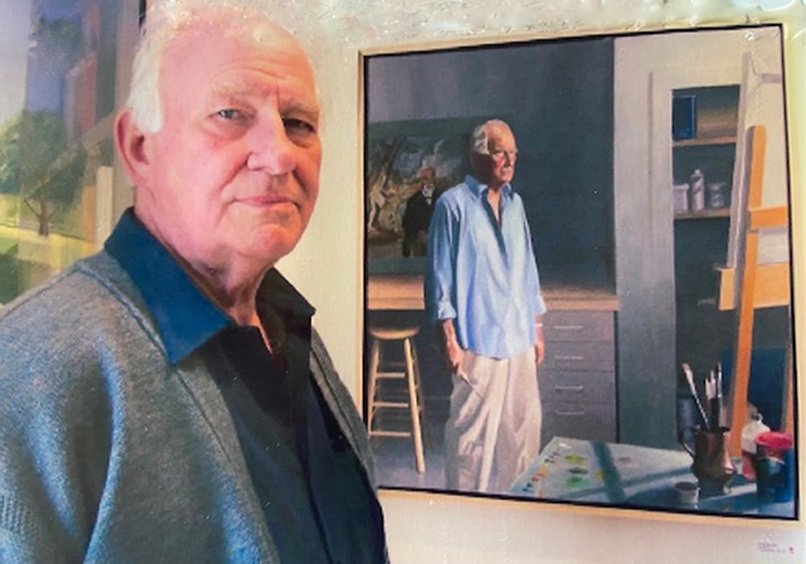 Architect John Rauch with a self-portrait he painted after his retirement.