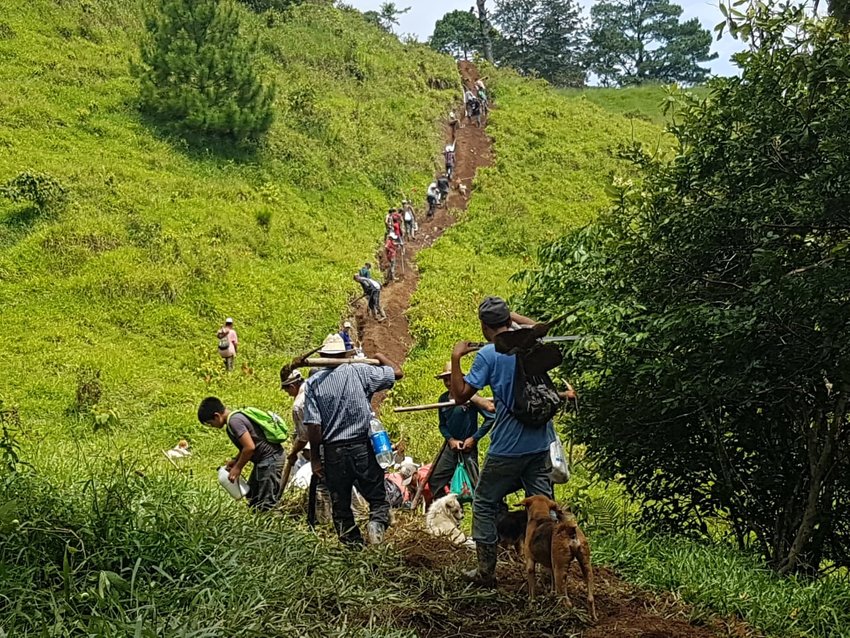 Honduran men putting in a trench line for piping to get the water from the source to the village.