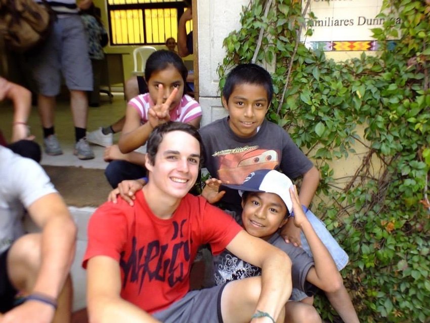 Dwyer, in red T-shirt, with youngsters in Guatemala, where most of the country's residents live on less than $2 a day.