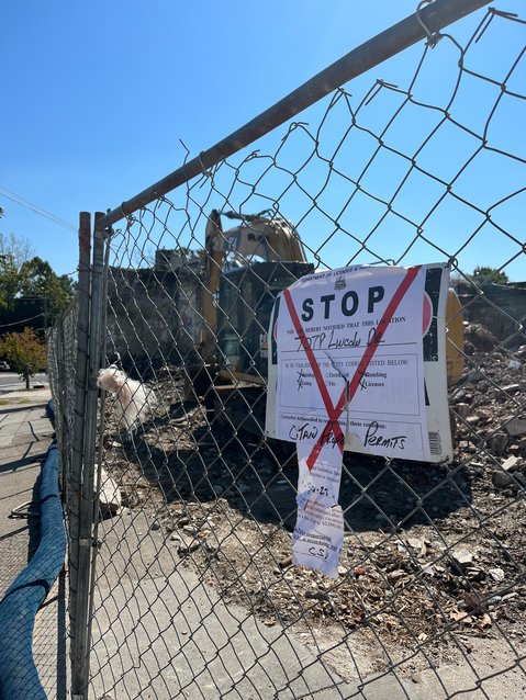 Construction on the site of the old stone garage that was demolished without a permit has been ordered to a halt by city officials.