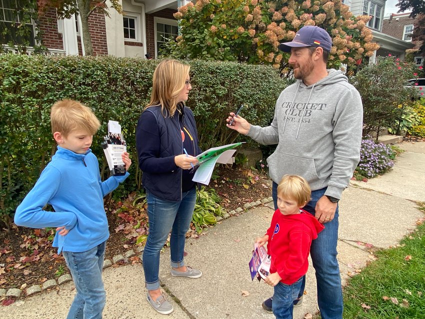 Eryn Santamoor, a Democratic committeeperson in the 9th ward, talks with her Chestnut Hill neighbors as she canvassed the neighborhood on Sunday.