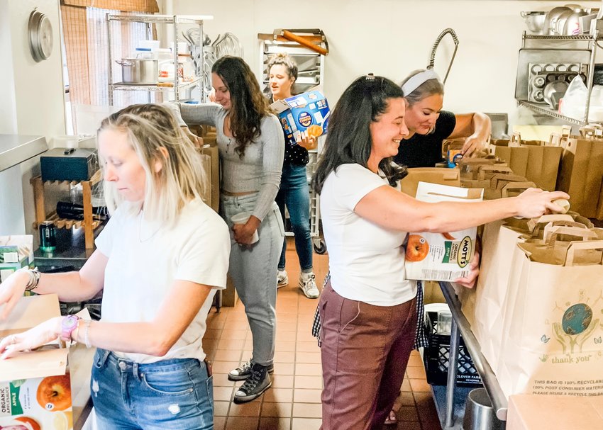 A group of volunteers gathers every Thursday to pack grocery bags for needy families. Shown here, from left to right, are Bevin Reilly, Casia Mioduszawski, Georgia Carey, Annabel Wulfhart and Linda Motter.
