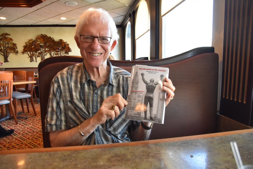 The late Rich Krassen holds up his memoir, &ldquo;Breadcrumbs on My Journey,&rdquo; written in his late 70s before he was diagnosed with stage 4 pancreatic cancer.