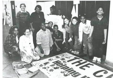 This photograph ran in the March 13, 1997 Chestnut Hill Local, with the caption &ldquo;J.S. Jenks School fourth grade teacher Linda Getter, teaching assistant Eudora Wiggins; parent volunteers Joanne Brown and Jane Kutzer; students Vinson Jones, Khattish Ahmadiya, Darius Egin, Tonya Khakis, Ebony Madison, Melissa Konowal, Kira Hanlan, Dyandra Brown and Chris Mitchell , with a banner referring to the proposed building of a Children's Park to be built on school grounds by the Chestnut Hill Community Association Park Committee.&rdquo;