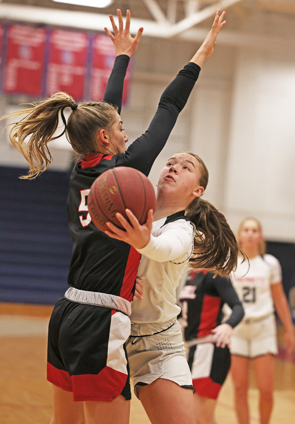 Gabby Bowes (right), a GA sophomore, reaches around Carroll's Brooke Wilson to get off a lay-up.