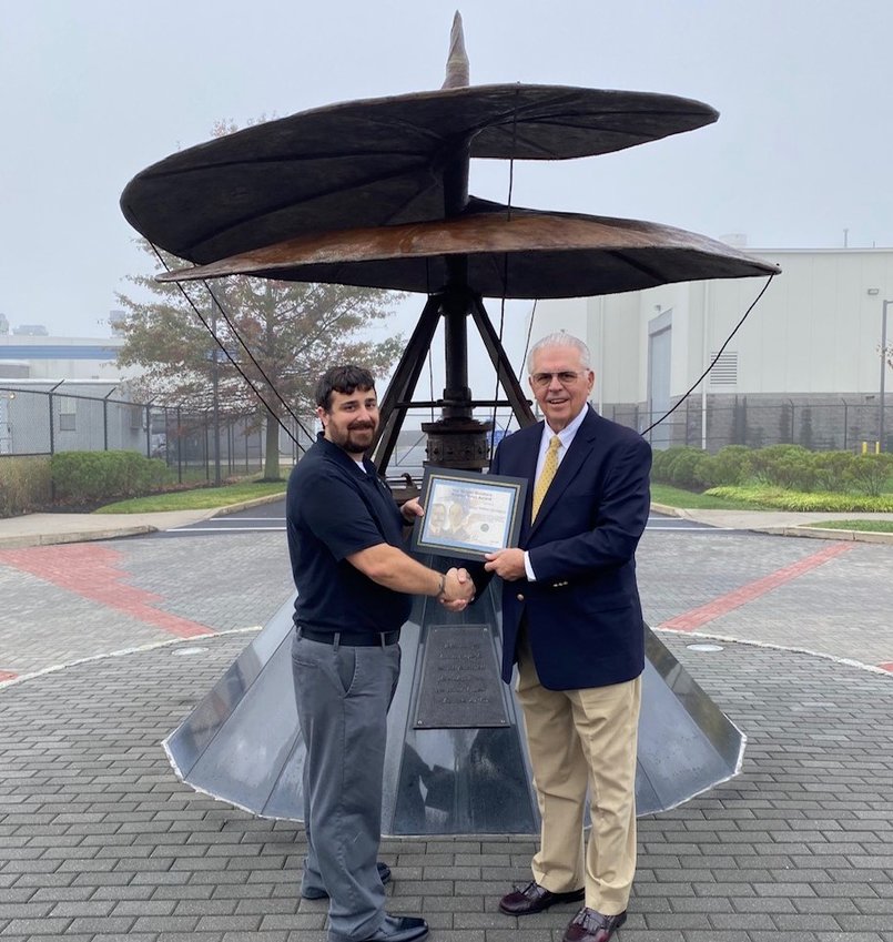 Harrington (right) is given the Wright Brothers Master Pilot Award in October by Eric Sieracki, of the Federal Aviation Administration, in front of the Leonardo Da Vinci model of a helicopter at Northeast Philadelphia Airport.